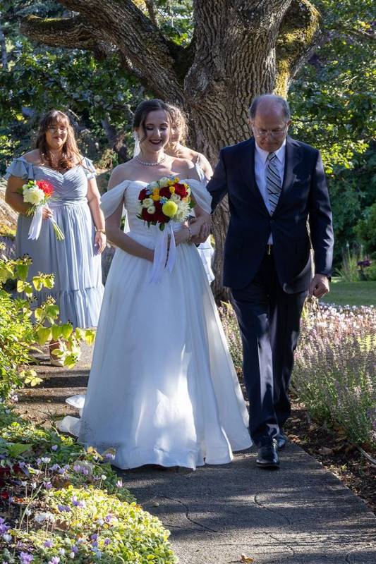 Bride walking down a garden aisle on her father's arm