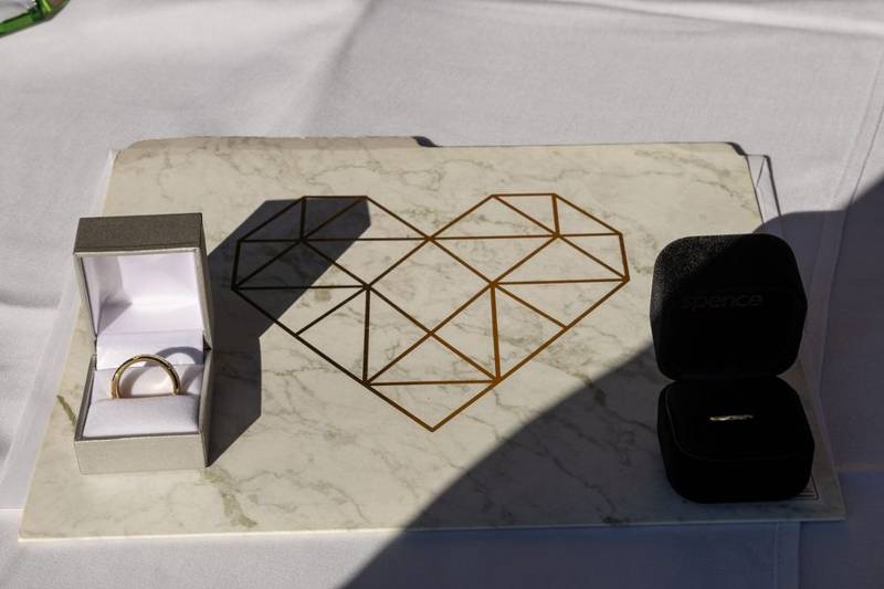 Wedding rings in their boxes on a marble ring tray