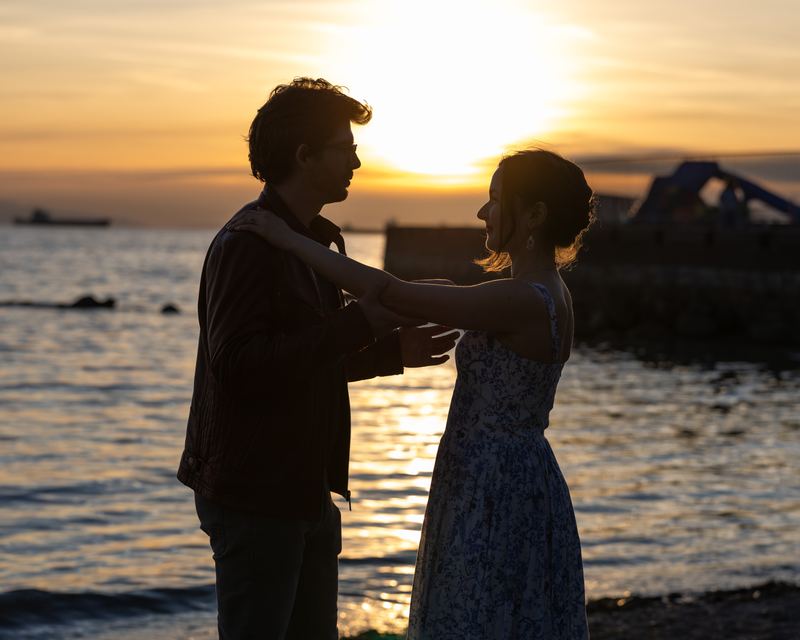 Silhouette of an engaged couple facing each other at sunset by the ocean in Vancouver