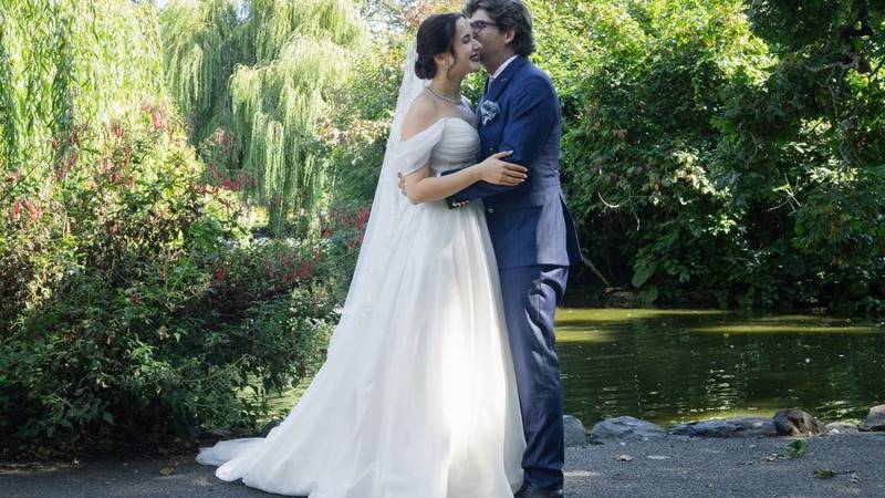 Couple kissing beside a pond under weeping willows