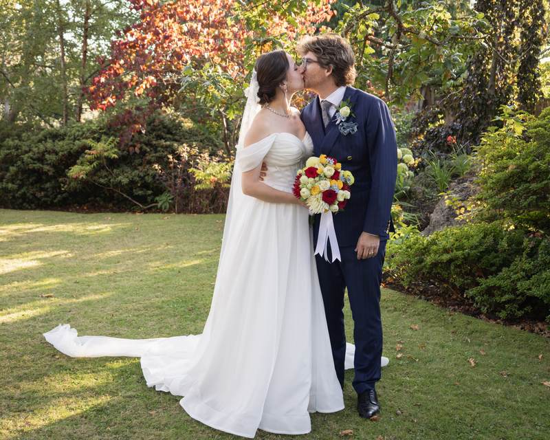 Chris and Lorena kissing on the lawn of a Vancouver garden on their wedding day